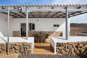 a white house with a stone wall at Casa Rosavi in Villaverde