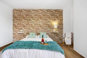 a bedroom with a bed and a brick wall at Casa Rosavi in Villaverde