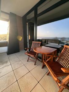 eine Terrasse mit einem Tisch und Stühlen auf dem Balkon in der Unterkunft Waterfront, idyllische Ferien direkt am Wasser mit Blick über die Flensburger Förde in Harrislee