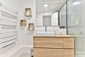 uma casa de banho com um lavatório e um espelho em Maison d'architecte à 15 min du centre de paris ! em Asnières-sur-Seine
