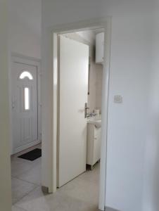 eine weiße Tür in einer Küche mit einem Waschbecken in der Unterkunft Vini in Kruševo