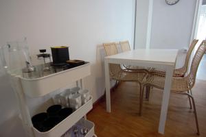 uma mesa branca e cadeiras num quarto em RentalSevilla cerca del Salvador em Sevilha