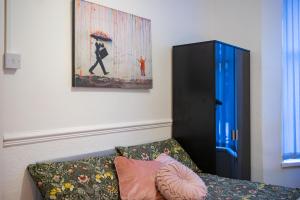 una sala de estar con sofá y una pintura en la pared en Cozy rooms in shared accommodation near Anfield Stadium with PARKING and WIFI en Liverpool