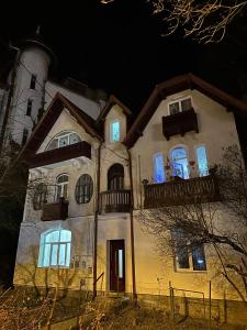een oud huis met 's nachts verlichting in de ramen bij Cazare central Sinaia, Romania in Sinaia
