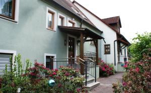 Pension Hessenmühle في Haundorf: البيت الأبيض مع الزهور أمامه