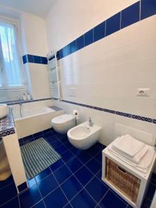 un bagno bianco e blu con servizi igienici e lavandino di WANDERLUST Splendido appartamento in centro a Pavia