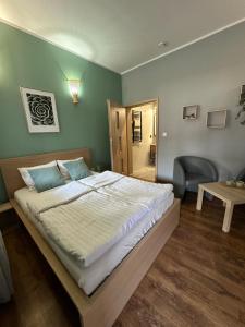 a bedroom with a large bed and a chair at Hotel Nenufar Premium in Kościan