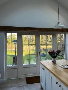 a kitchen with glass doors and a counter with flowers on it at Favour Royal Cottage - dog friendly forest escape in Derrygorry +26 photos