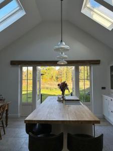 uma mesa de jantar numa cozinha com uma grande janela em Favour Royal Cottage - dog friendly forest escape em Derrygorry