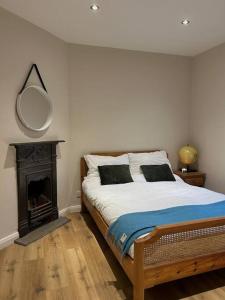 a bedroom with a bed with a fireplace and a mirror at Favour Royal Cottage - dog friendly forest escape in Derrygorry