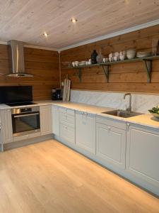 a kitchen with white cabinets and a sink at Villa Flo in Stryn