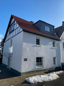 una casa bianca con tetto rosso di Ferienhaus auffm Hebberg ad Attendorn