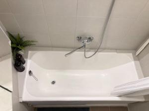 a white bath tub with a shower head in a bathroom at 1840 Old Town Nook in Kaunas