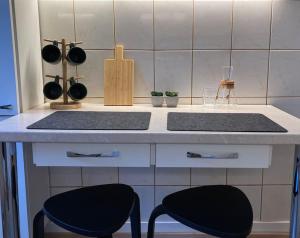 a kitchen with two black stools at a counter at 1840 Old Town Nook in Kaunas