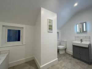 a white bathroom with a sink and a toilet at Ellergill in Keswick
