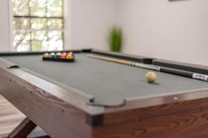 a pool table with a ball and cues on it at Luxury 6br Home, Game Room By Lackland & Seaworld in San Antonio
