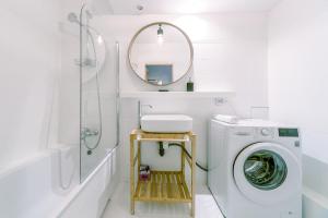a white bathroom with a washing machine and a mirror at Warsaw Concierge Opera II in Warsaw