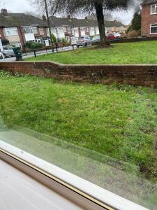a view from a window of a grassy yard at 2 bed modern ground floor apartment in Tollbar End