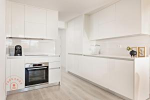 cocina blanca con armarios blancos y horno en Perfect apartment 3 - TCM, en Fuengirola