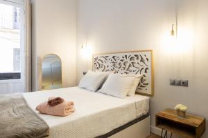 Un dormitorio con una cama con una toalla. en Strachan Apartamentos en el corazón de Málaga, en Málaga