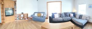 sala de estar con sofá y 2 sillas en Large Buncrana Holiday Home - 2min drive to Beach, en Garrynabullogy