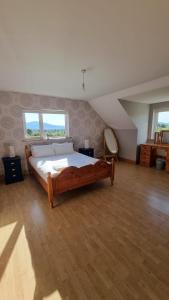 1 dormitorio con 1 cama grande en una habitación en Large Buncrana Holiday Home - 2min drive to Beach, en Garrynabullogy