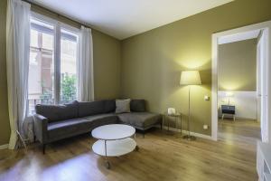 uma sala de estar com um sofá e uma mesa em Ola Living Aribau Apartments em Barcelona