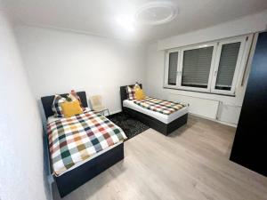 sypialnia z 2 łóżkami i oknem w obiekcie Relax Wohnung Bickenbach w mieście Bickenbach
