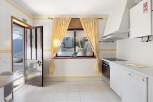 una cocina con electrodomésticos blancos y una ventana en Gilove House, en Póvoa de Varzim