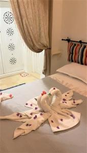 dois pássaros de toalha sentados em cima de uma cama em Hôtel Djerba Authentique - Au centre de Midoun em Midoun