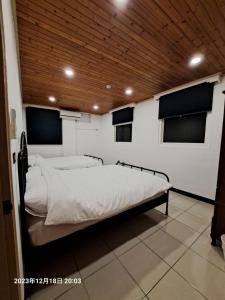 a large bed in a room with a wooden ceiling at Mi Casa Homestay in Jiufen