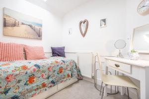 a bedroom with a bed and a desk and a table and chairs at Victory Cottage in Little Walsingham