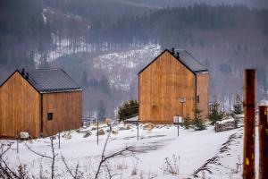 two large wooden barns in a snow covered field at Loft Point 1 