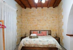 1 dormitorio con cama y pared de ladrillo en Home Sweet Home Milos en Triovasálos