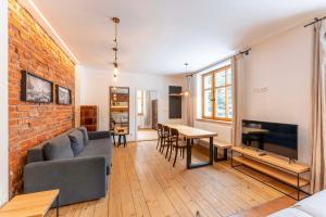 a living room with a couch and a tv and a brick wall at Vila Kouty in Loučná nad Desnou