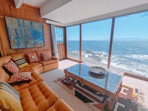 a living room with a couch and a table at Timber's Ocean House in Simonʼs Town +291 photos