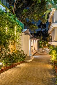 un patio nocturno con un edificio y árboles en Quality Inn Ocean Palms Goa, en Calangute