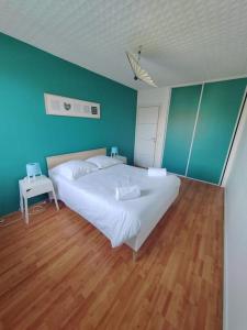 ein Schlafzimmer mit einem weißen Bett und einer blauen Wand in der Unterkunft L'Edison *T3* proche hôpital in Orléans