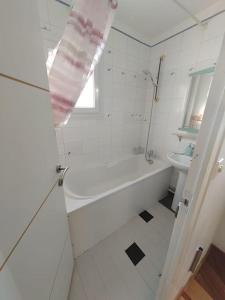 een witte badkamer met een bad en een wastafel bij L'Edison *T3* proche hôpital in Orléans
