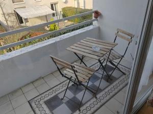 een houten tafel en stoel op een balkon bij L'Edison *T3* proche hôpital in Orléans
