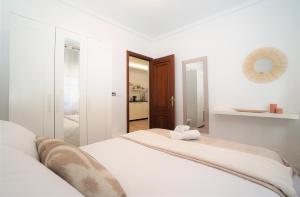 Habitación blanca con 2 camas y espejo. en Centro ciudad, en Lugo
