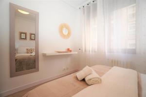 Habitación blanca con cama y espejo en Centro ciudad, en Lugo