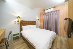 a bedroom with a white bed and a window at B&B near the seaside in Jian