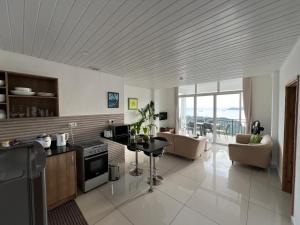 a kitchen and living room with a view of the ocean at Creole Pearl Self-Catering in Victoria
