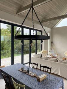 a dining room with a table and a chandelier at Luxurious design villa near beach - sleeps 8+ in Klintehamn