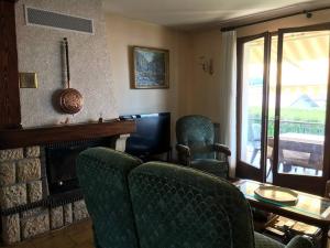 a living room with two chairs and a fireplace at Comme chez Mamie, maison entière 1-6 personnes in Alby +16 photos