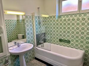 W łazience znajduje się umywalka, wanna i prysznic. w obiekcie APPARTEMENT MAISON, CENTRE VILLE, PROCHE PLAGE TOUT COMMERCE w Mentonie