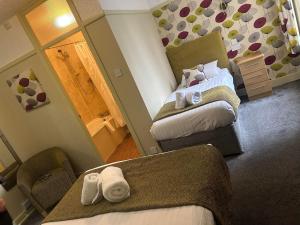 a hotel room with two beds and a mirror at The Savoy in Skegness +39 photos
