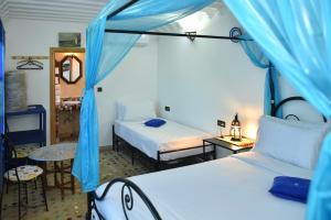- une chambre avec 2 lits et une tente bleue dans l'établissement Riad Fes EL KAID, à Fès