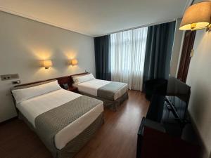 Кровать или кровати в номере Hotel Compostela Vigo